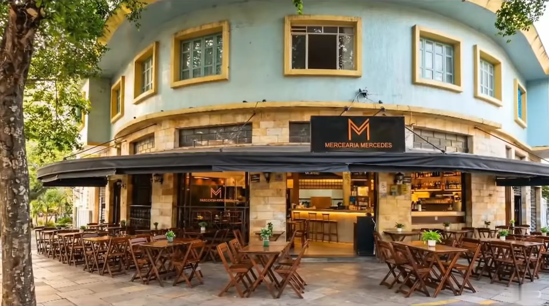Fachada da Mercearia Mercedes vista da esquina, com as mesas na calçada